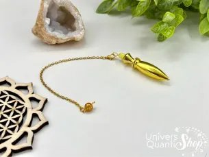 pendule divinatoire égyptien thot métal plaqué or sur fond blanc avec une petite géode de quartz