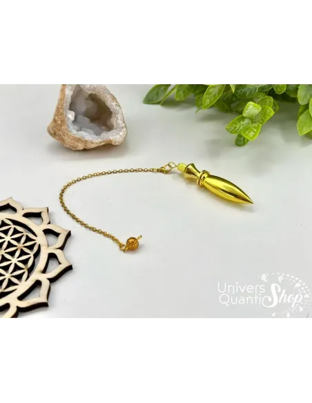 pendule divinatoire égyptien thot métal plaqué or sur fond blanc avec une petite géode de quartz