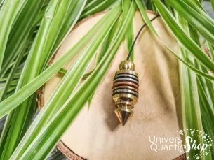 pendule sensoriel 7 métaux posé sur un support en bois