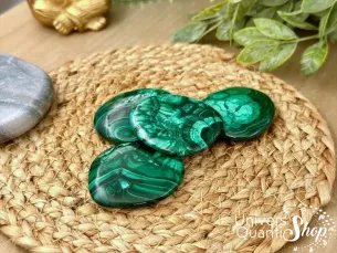 malachite pierres plates sur un support rond en paille, pierre de guérison