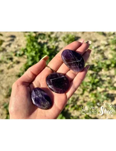 améthyste pierre plate, pierre violette naturelle posée dans une main