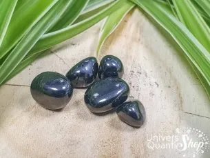 shungite pierre roulée naturelle grise sur un support en bois