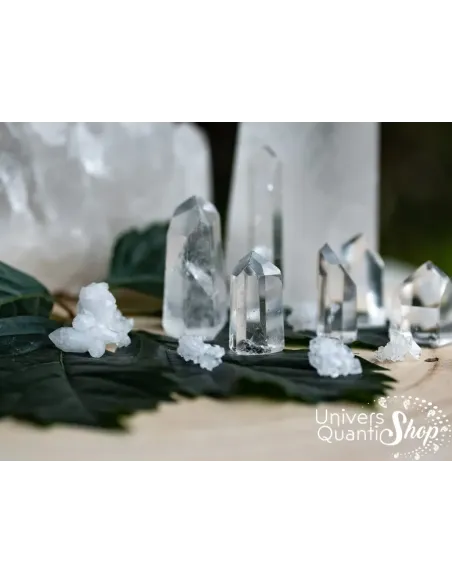 cristal de roche pointes de différentes tailles sur une feuille avec amas de quartz en fond