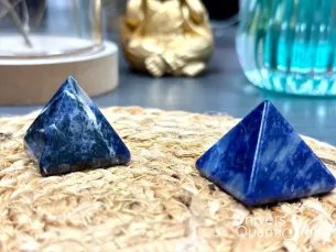pyramides sodalite pour la maitrise de soi posées sur un support rond en rotin