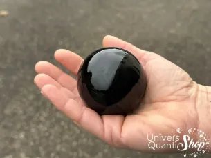 obsidienne noire sphère en pierre naturelle posée dans une main