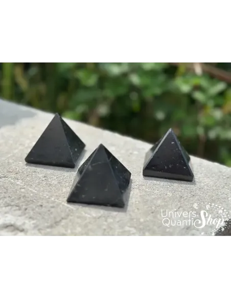 pyramides tourmaline noire posées sur une dalle en extérieur