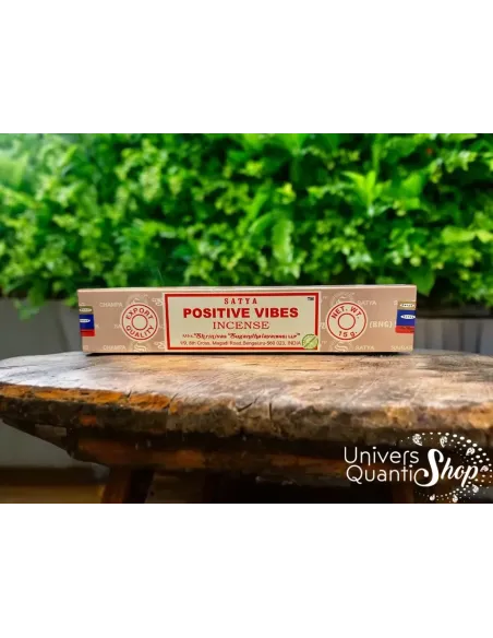 encens satya positive vibes posé sur une petite table en bois en extérieur