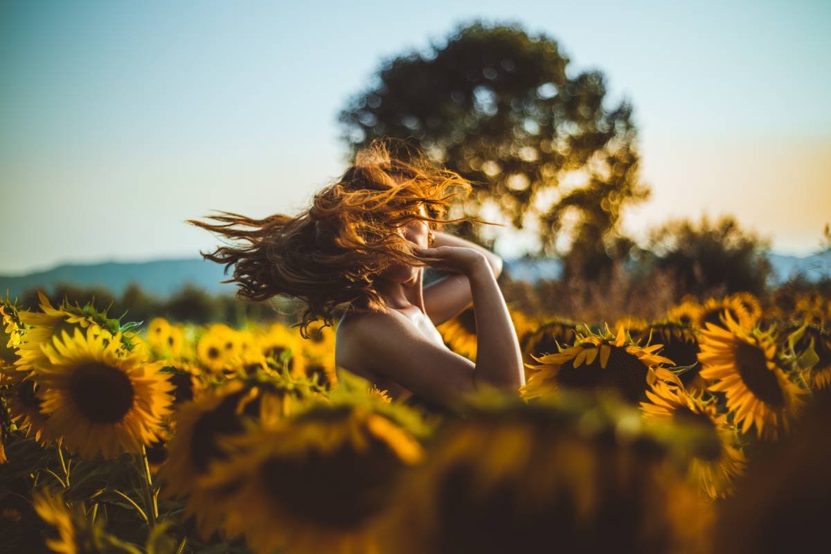 femme tournant dans un champ de tournesol au soleil couchant fete litha