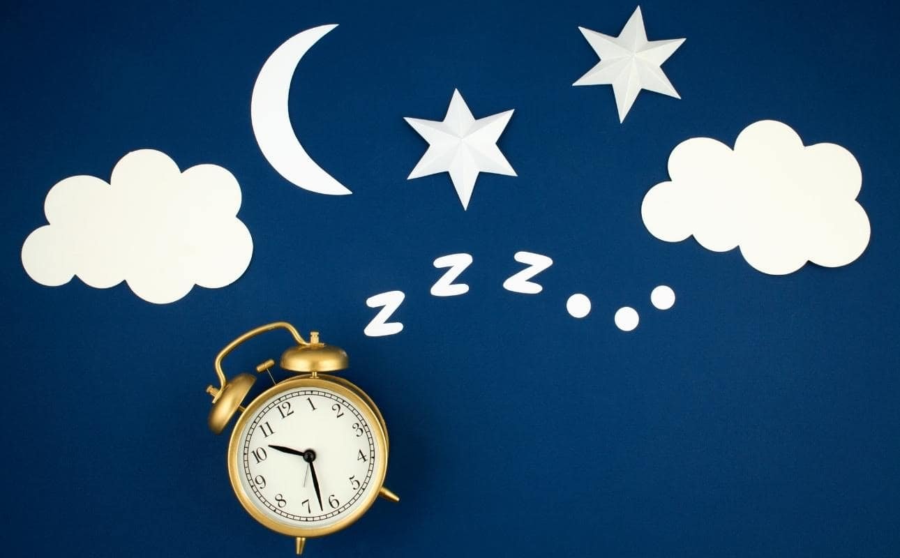 réveil doré sur fond bleu avec nuages et lune pour le sommeil