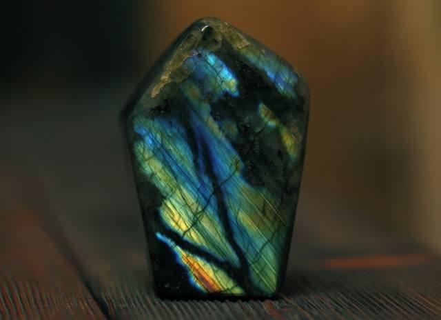 pierre labradorite avec reflets posée sur planche de bois pour hypersensibilité