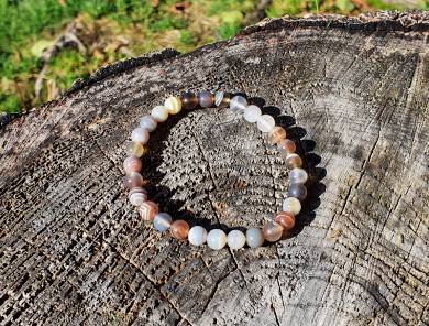 bracelet agate botswana en 6 mm posé sur un tronc d'arbre